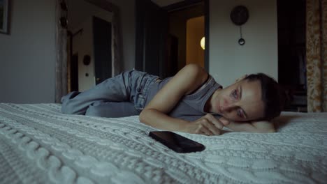 una mujer acostada en la cama, molesta y llorando.