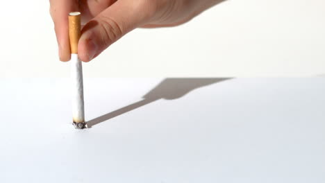 Woman-crushing-a-cigarette-on-a-white-table