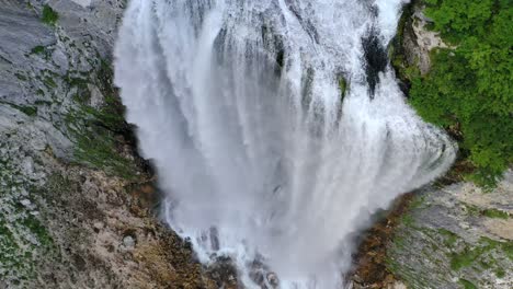 Medium wide angle aerial drone shot of beautiful boka waterfall spring and surrounding trees during the day