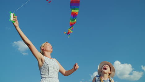 A-Carefree-Woman-Plays-With-Her-Daughter-A-Girl-Tries-To-Catch-An-Air-Kite-Against-The-Background-Of