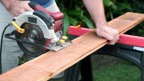 slow motion wood working, sawing through wood with electric round saw