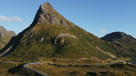 fredvang lofoten 노르웨이에서 바다를 가로지르는 상징적인 다리를 건너 잔디로 덮인 산으로 날아갑니다.