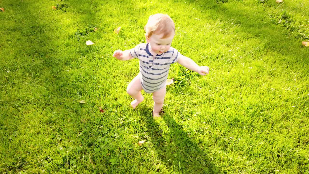 Happy toddler takes first steps alone in grass | Premium Stock Video ...