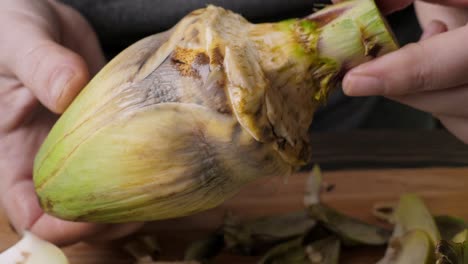 Woman-cleaning-artichokes.-Cooking-process-at-the-kitchen.-Closeup