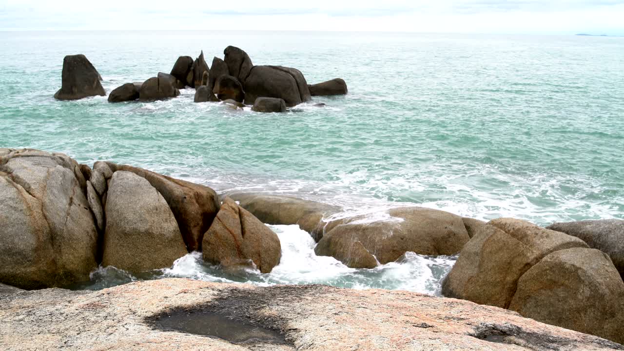 바다의 파도가 바위 위에 부히고