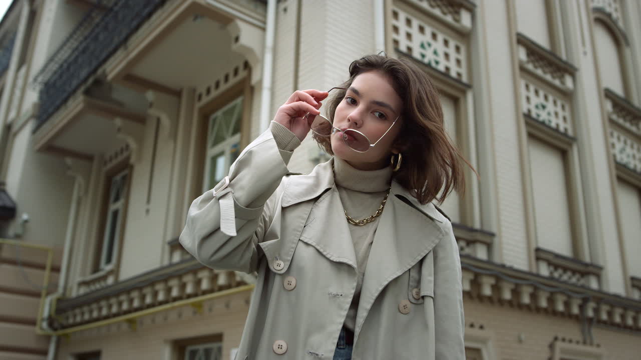 집중된 여성은 야외에서 카메라를 찾고 있습니다.