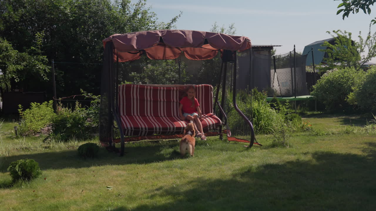 Sunlit Chase Scene With Caucasian Girl Running And Corgi Following Through Garden, High Energy Play, Blurred Motion And Playful Laughter, Open Lawn With Small Play Tent, Carefree Summer Activity