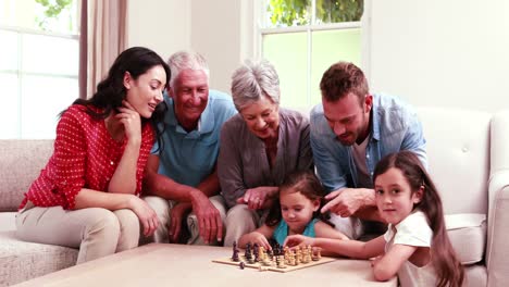 familia sonriente jugando al ajedrez