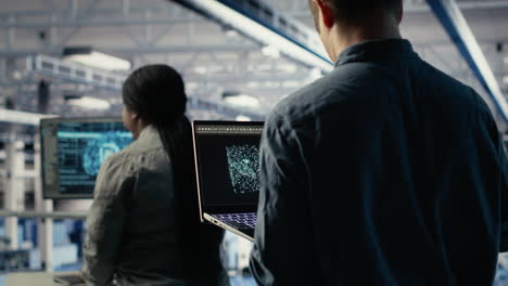 software developer in data center checks ai dashboard using laptop