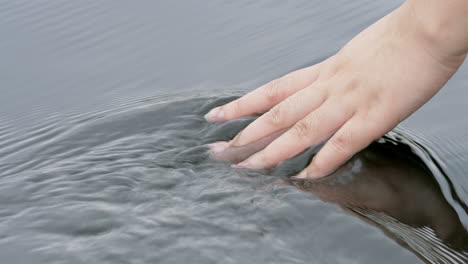 Mano-Tocando-El-Agua-En-El-Río-O-Lago-Del-Bosque