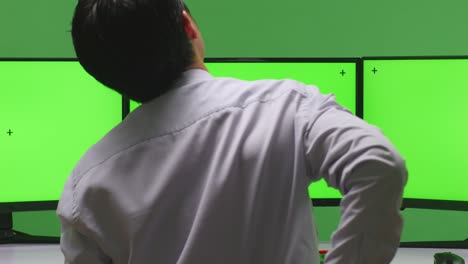 hombre monitoreo múltiples monitores de pantalla verde