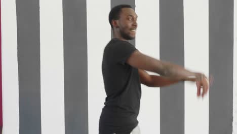 man dancing in front of a striped wall