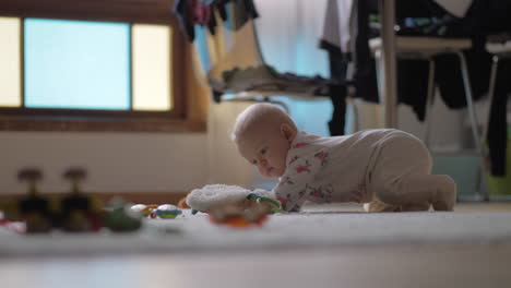 baby girl crawling on the floor with toys