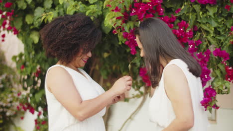 happy african-american woman proposing marriage to her girlfriend and putting ring on her lover's finger