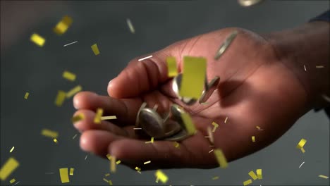 Animation-of-confetti-and-coins-falling-into-man's-hand-on-grey-background