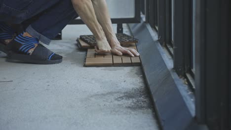 unrecognizable man placing interlocking deck tiles at the porch