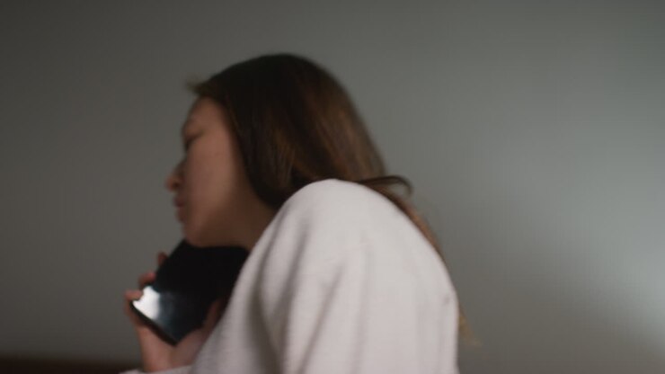 Donna arrabbiata, ansiosa o stressata a casa in salotto che discute al telefono cellulare. Ripresa in tempo reale 1.