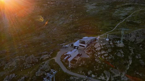 aerial of thredbo ski chairlift and mobile network towers in summer dry season with sun lens flare, nsw, australia