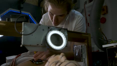 sci fi scene - young technician in a science fiction laboratory fixing a female droid