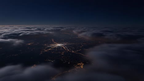 aerial view of city lights at night above clouds