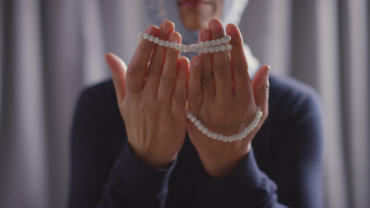 집에서 염주를 들고 기도하는 히잡을 쓴 이슬람 여성의 클로즈업 2