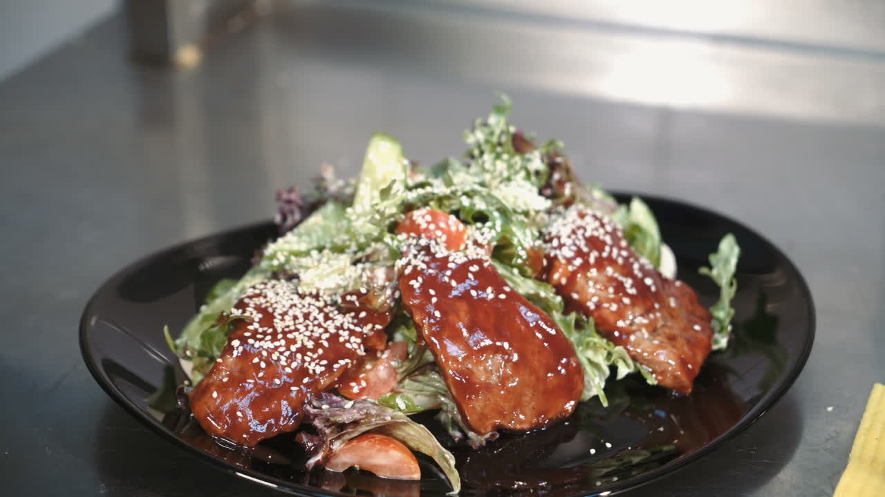 Chef is working on the presentation of the dish. Salad is decorated with sesame seeds.