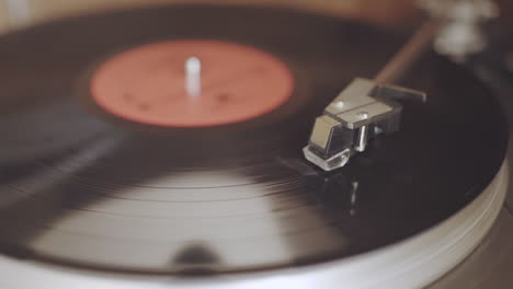 An-old-dusty-record-player-from-the-1970's-is-playing-a-black-vinyl-record-with-a-red-label