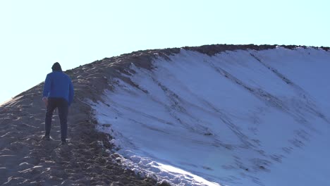 Man-hiking-over-sand-dunes-on-a-sunny-day