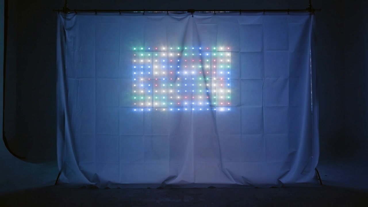 Accensione di un pannello LED a pixel, con pixel che scorrono su una tenda in studio, con morsetti e cavi per il test