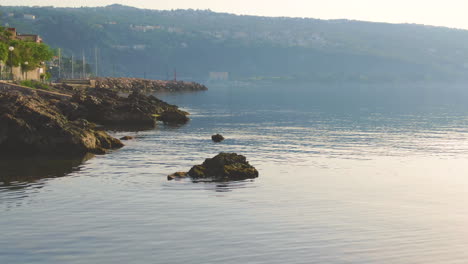 rocky seashore and city walls by the sea at sunset