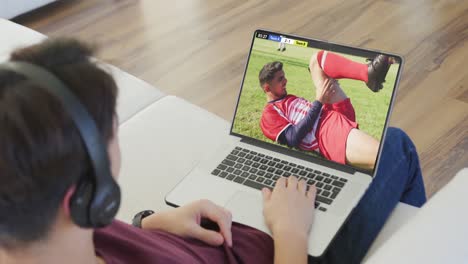 Video-Einer-Person,-Die-Auf-Der-Couch-Sitzt-Und-Sich-Ein-Fußballspiel-Auf-Dem-Laptop-Ansieht