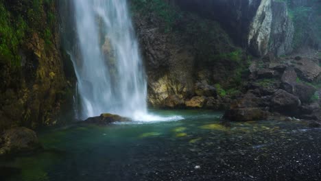 Waterfall-bottom-in-green-and-turquoise-colors,-water-splashing-furiously-on-cliffs-in-Theth,-Albania