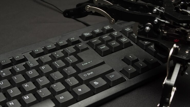 Mão robótica operando um teclado.