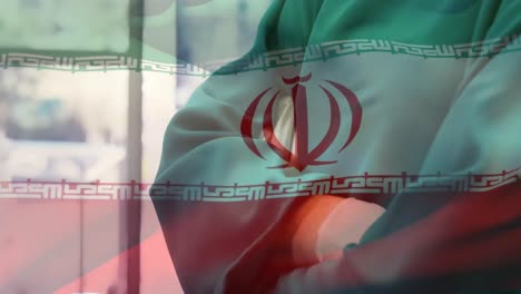 Animation-of-flag-of-iran-waving-over-surgeons-in-face-masks