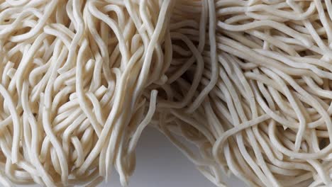 close-up of wheat noodles tangled together in a heap, showing their texture