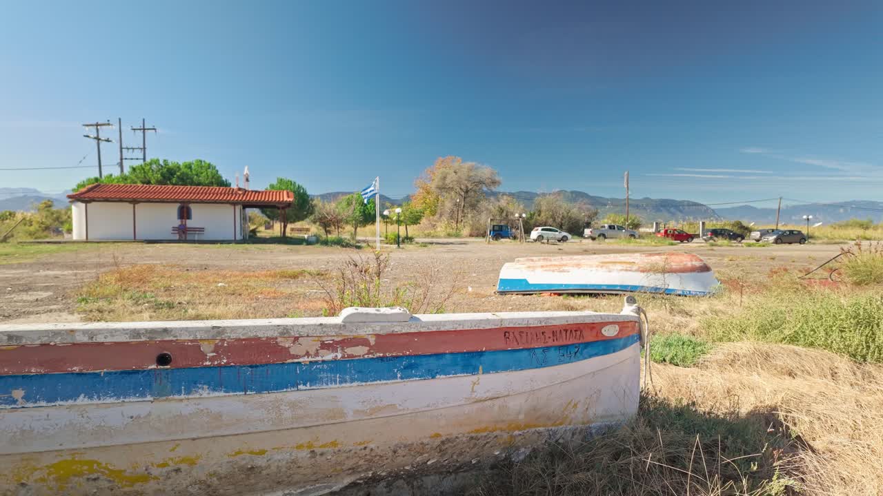 Abandoned Greek wooden fishing boats neglected on grassy beach