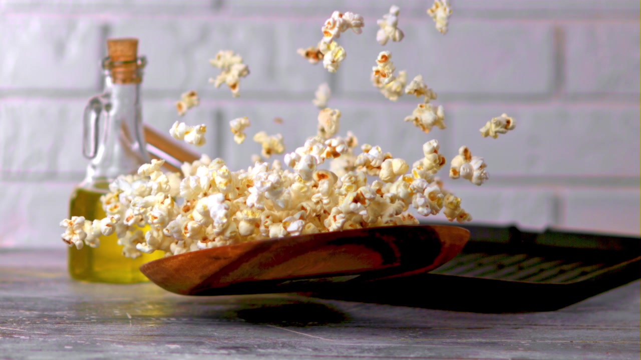 Popcorn che saltano e cadono in una ciotola al rallentatore