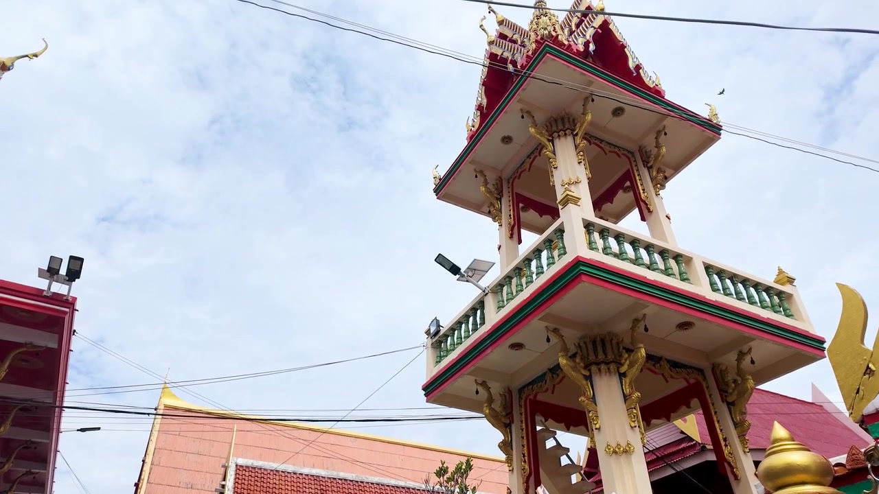 Cảnh quay góc thấp kiến trúc chùa Thái truyền thống trên nền trời nhiều mây sáng