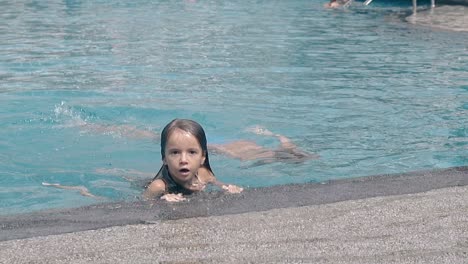 children swim and play in pool at exotic resort slow motion