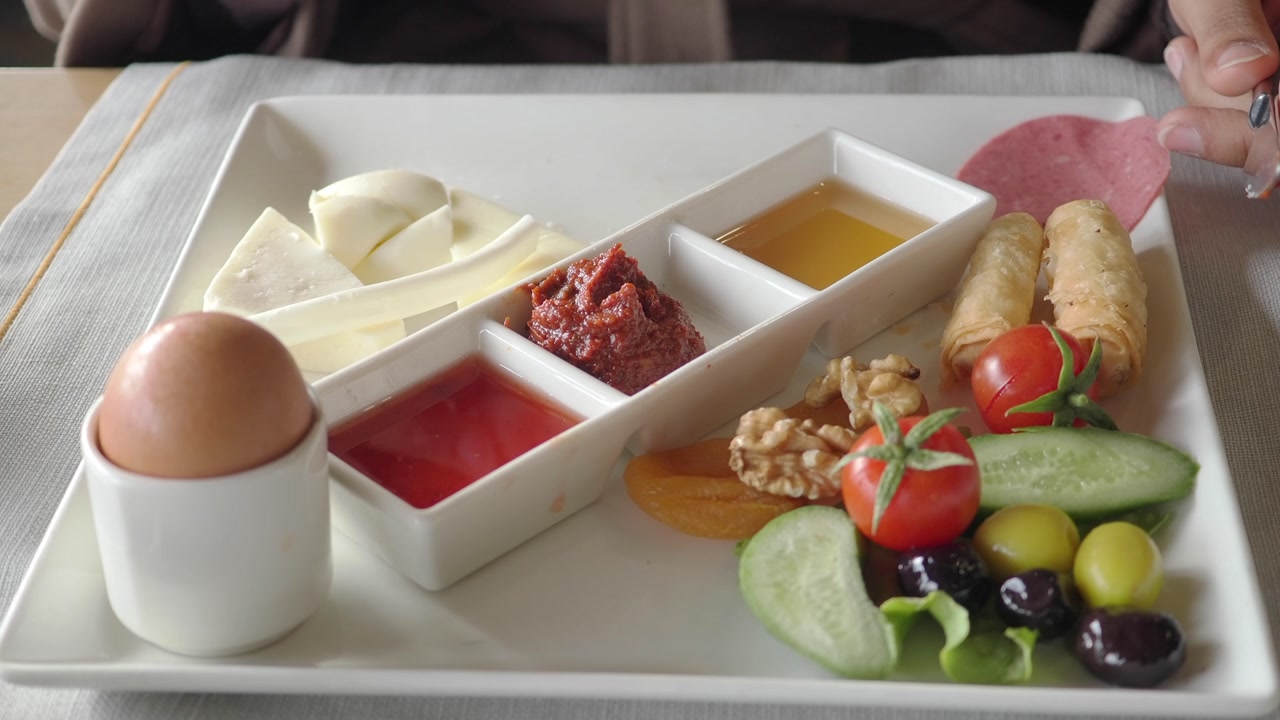 Person Eating a Healthy Breakfast with Various Foods