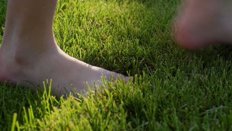 A-man-walks-on-green-grass,-leaves-a-trail.-Blades-of-grass-are-restored