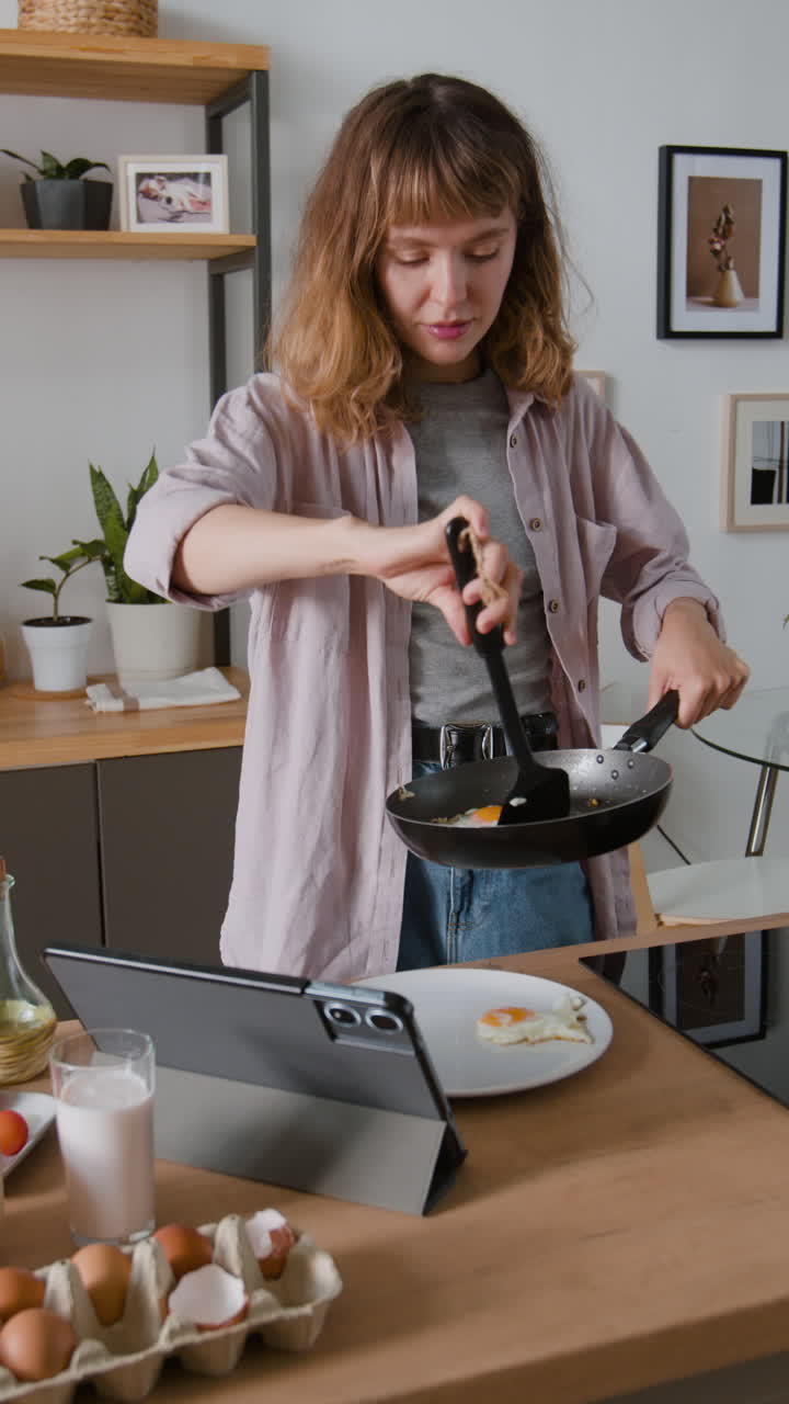 Woman cooking eggs in the kitchen