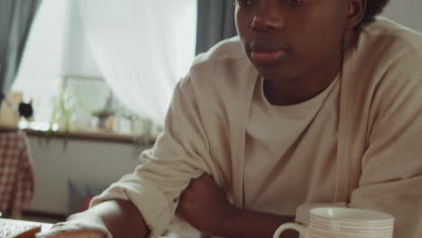 African-American-Woman-Using-Laptop-and-Drinking-Coffee-at-Home