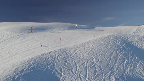 skiers on the slope of zwölferkogel mountain in saalbach-hinterglemm, austria - aerial shot