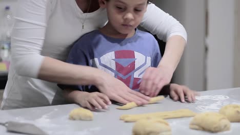 little boy learning to bake bread with his mother in the kitchen stock video