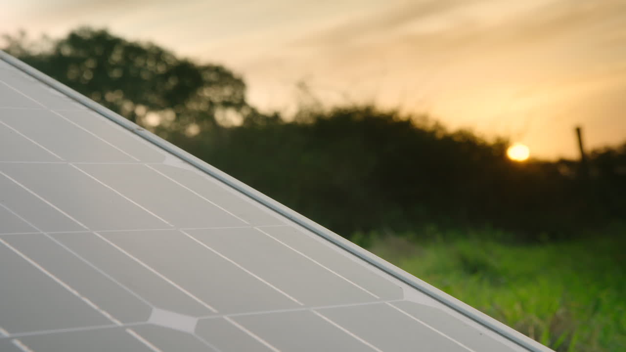 un primer plano de un panel solar fotovoltaico en un entorno rural a la hora dorada