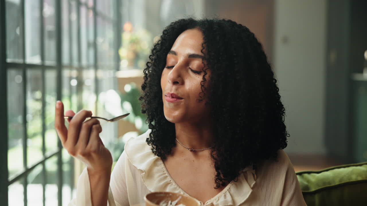 Young Woman with Curly Hair Enjoying a Snack from a Bowl