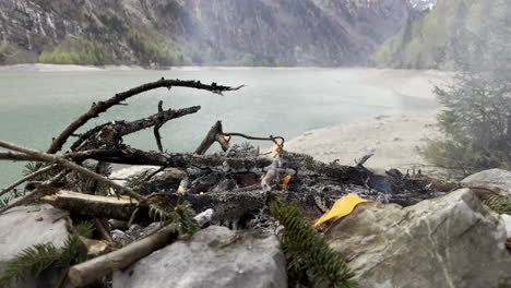 Ein-Feuer-Aus-Brennholz-Zum-Kochen-Bei-Einer-Abenteueraktivität-Am-Ufer-Des-Klöntalersees-Im-Kanton-Glarus-In-Der-Schweiz