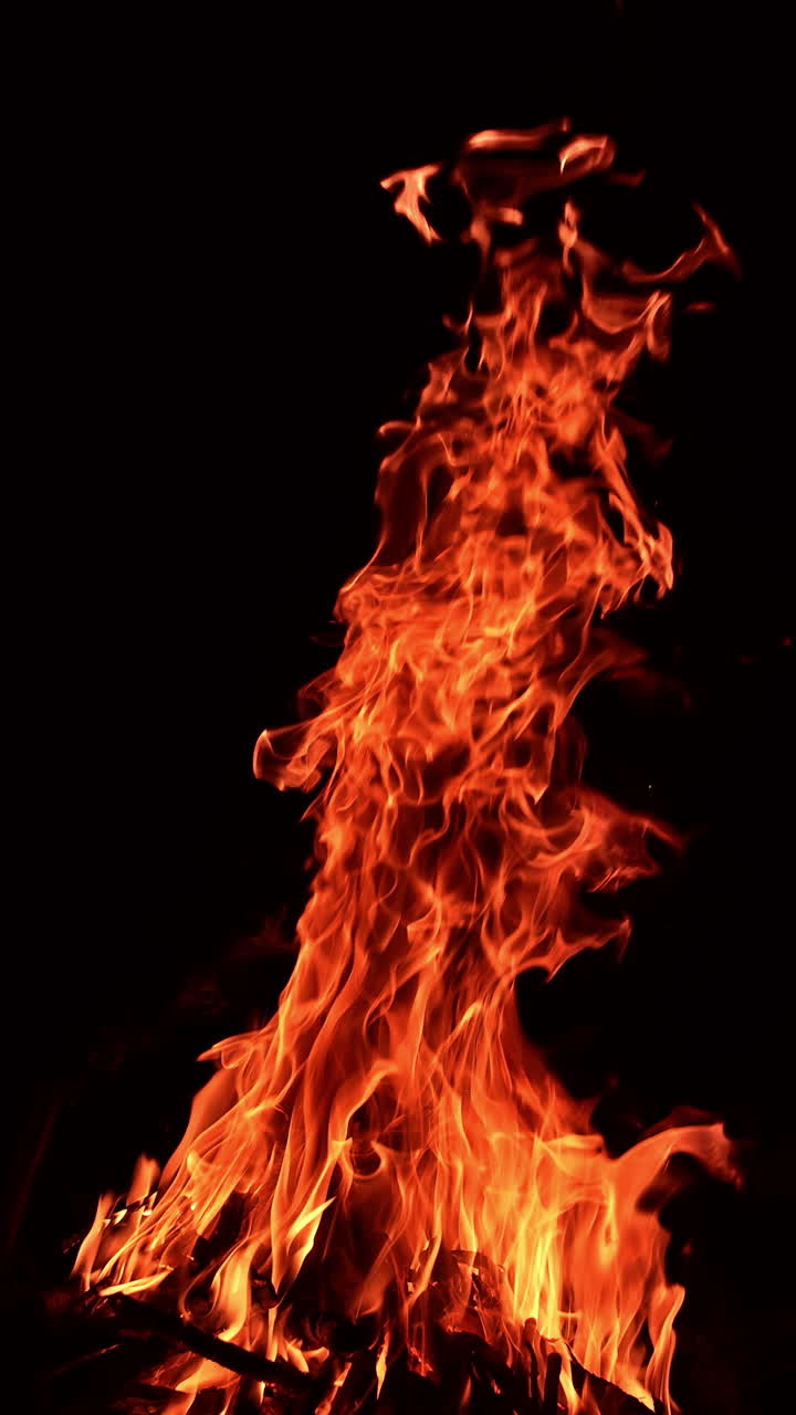 Burning campfire flaming motion. Flame glowing on black.