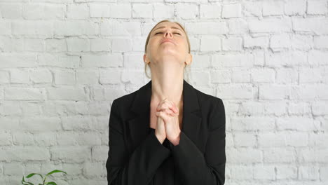 a woman praying with hands clenched together